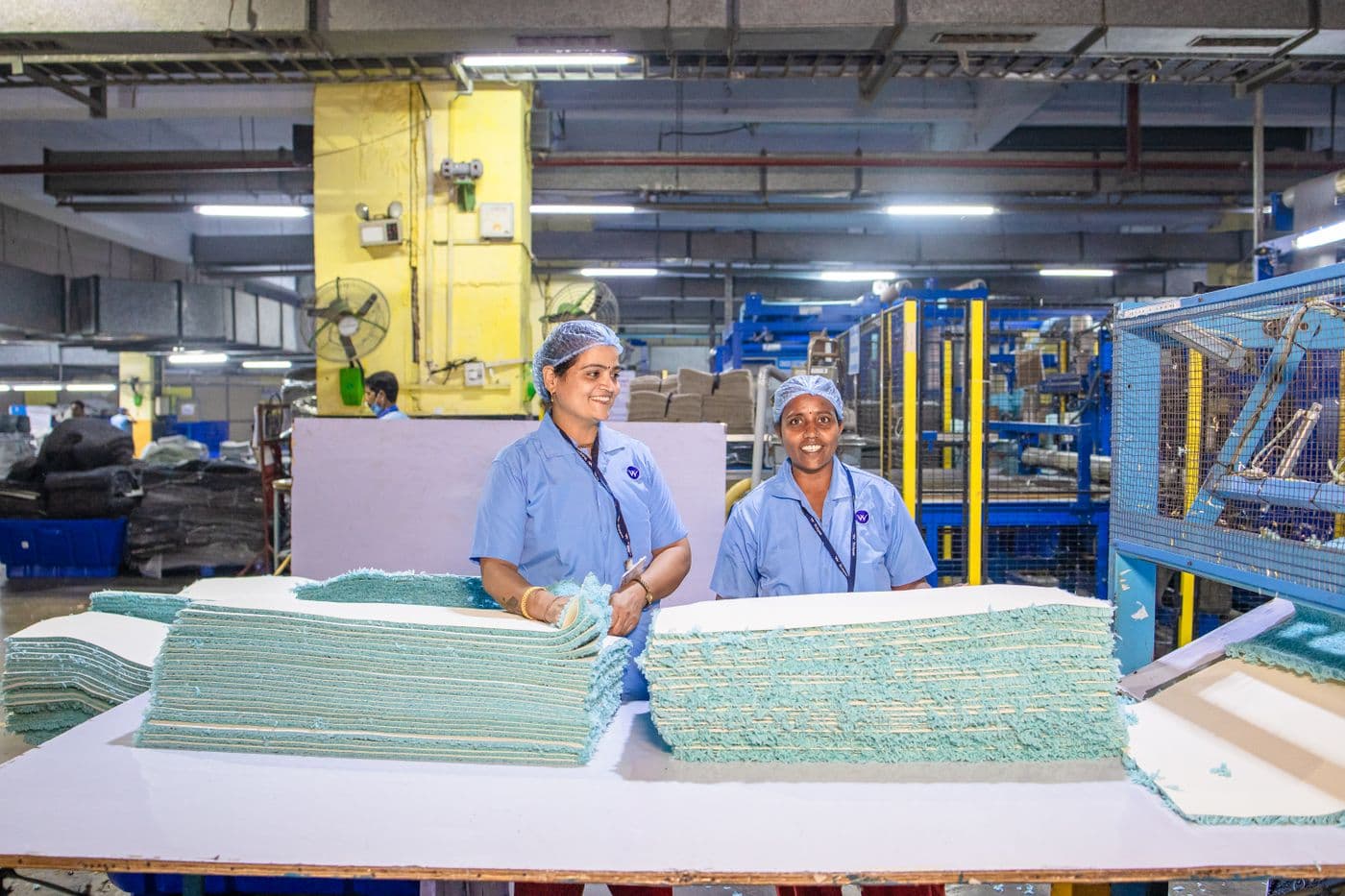 Textile workers operating machinery on a factory floor