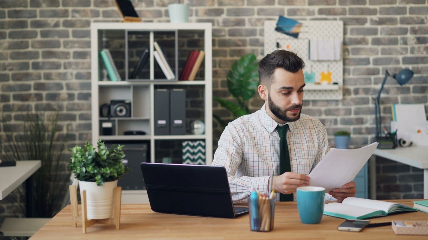 Professional reviewing printed research papers and notes