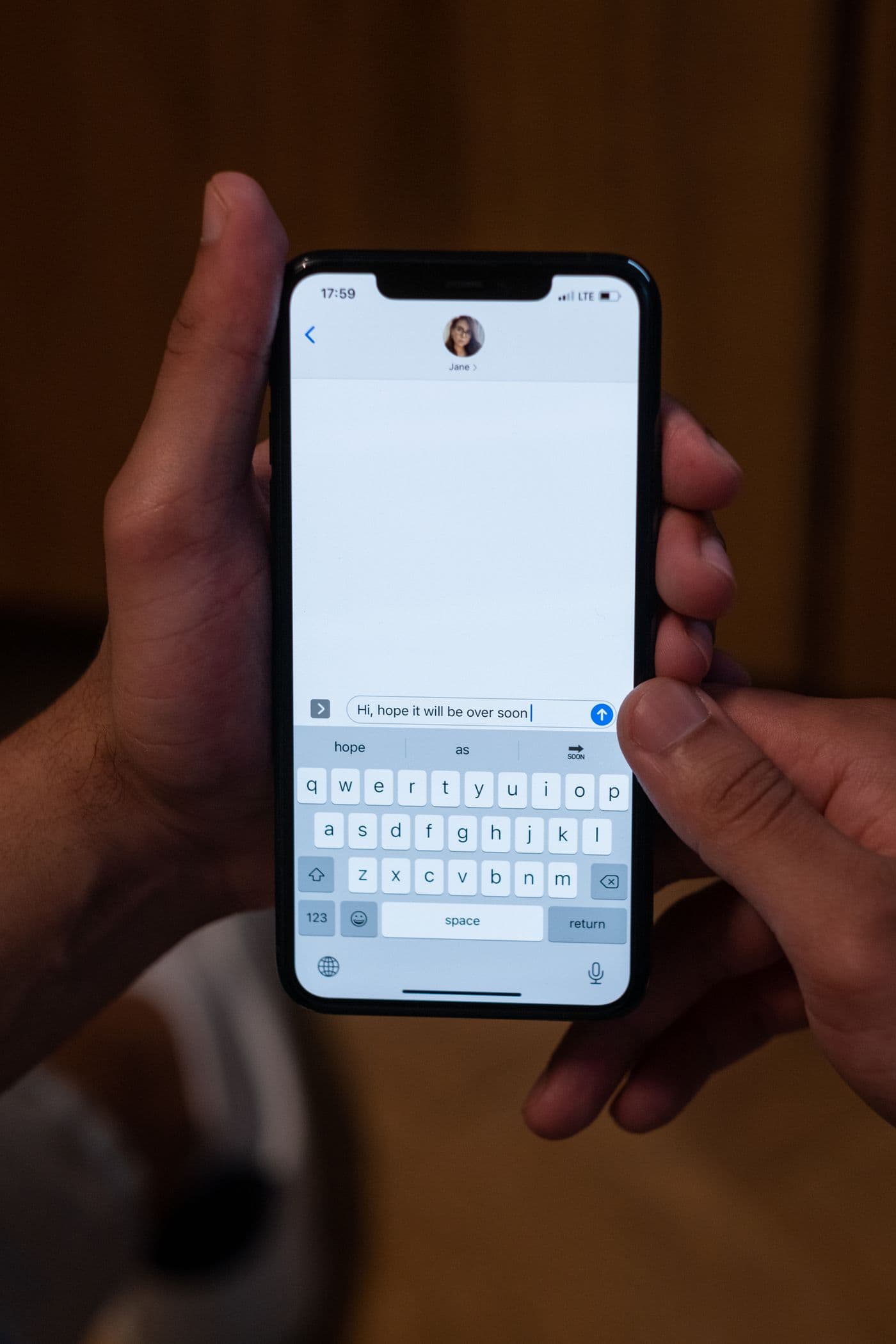 Hands using a smartphone to compose a text message